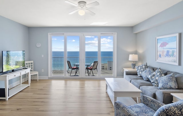 living room with a water view, ceiling fan, and light hardwood / wood-style floors