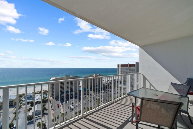 balcony with a water view and a view of the beach