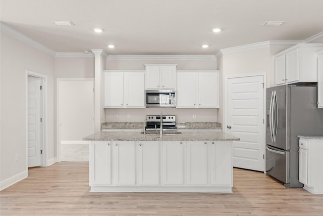 kitchen featuring stainless steel appliances, white cabinetry, and a kitchen island with sink