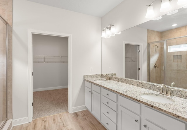 bathroom featuring a shower with door, wood-type flooring, and vanity