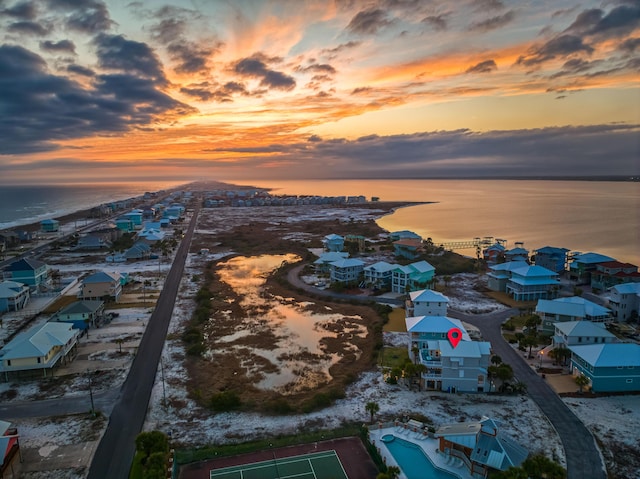 aerial view at dusk featuring a water view