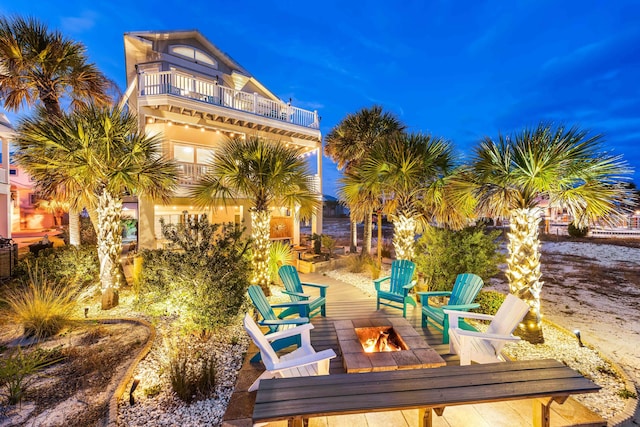 patio terrace at dusk with a balcony and a fire pit