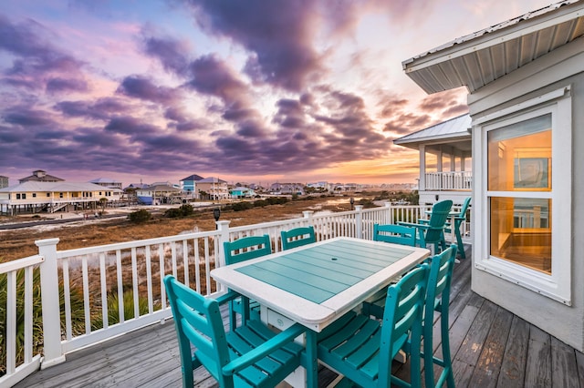 deck at dusk featuring a sunroom