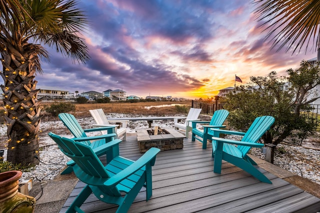 deck at dusk featuring a fire pit