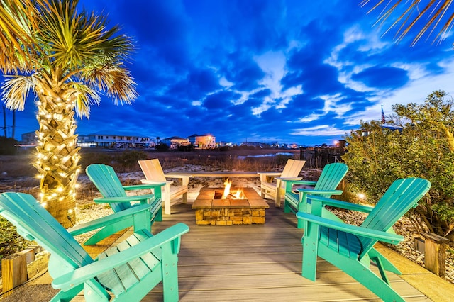 deck at dusk featuring an outdoor fire pit