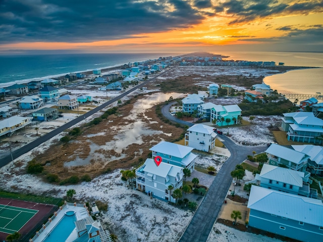 aerial view at dusk featuring a water view