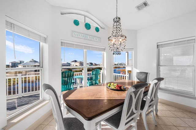 tiled dining room with a chandelier