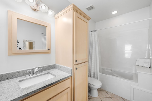 full bathroom featuring vanity, shower / bath combo with shower curtain, tile patterned floors, and toilet