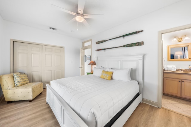 bedroom featuring ensuite bathroom, a closet, ceiling fan, and light hardwood / wood-style floors