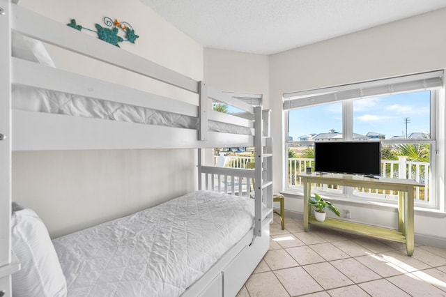 bedroom with a textured ceiling and light tile patterned floors