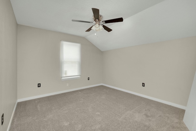 additional living space featuring a textured ceiling, ceiling fan, vaulted ceiling, and light carpet