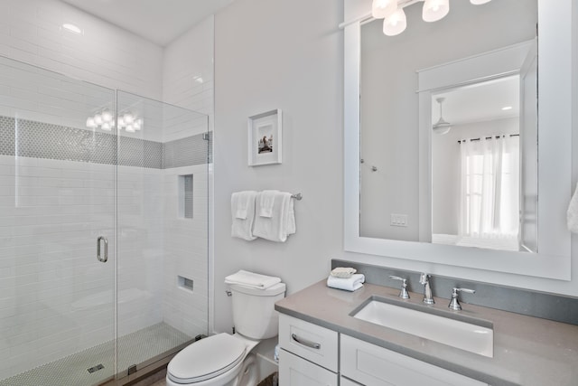 bathroom featuring vanity, walk in shower, and toilet