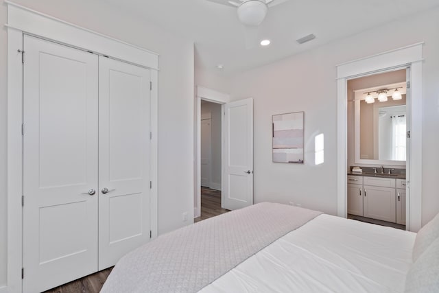 bedroom featuring ensuite bathroom, dark wood-type flooring, ceiling fan, and a closet