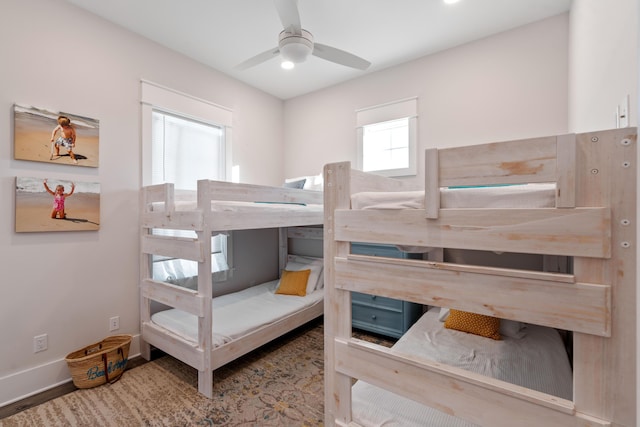 bedroom with multiple windows, wood-type flooring, and ceiling fan