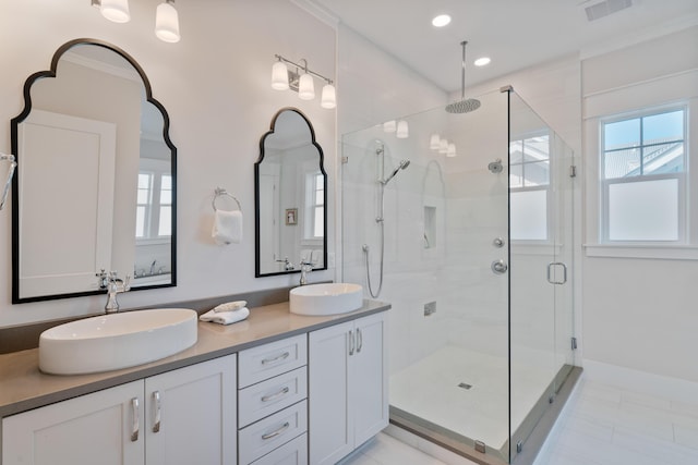 bathroom featuring vanity, ornamental molding, and a shower with door