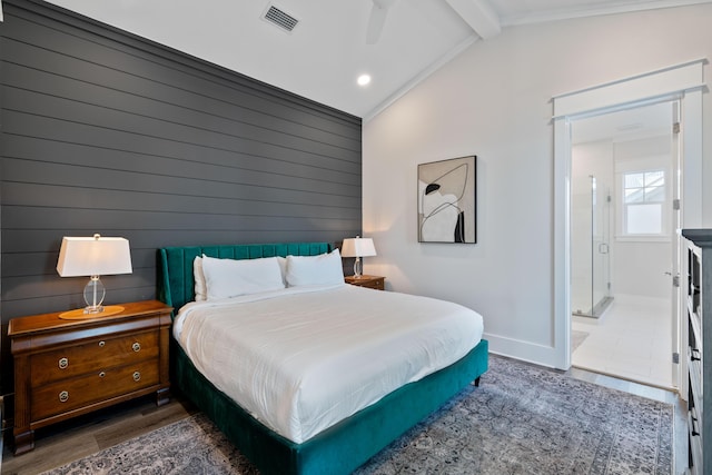 bedroom with vaulted ceiling with beams, ensuite bath, wooden walls, dark hardwood / wood-style floors, and ceiling fan