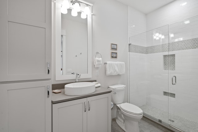 bathroom featuring vanity, a shower with shower door, and toilet