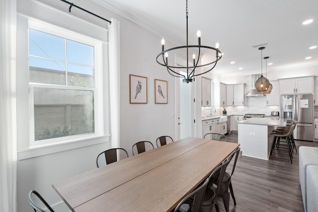 dining space featuring ornamental molding, dark hardwood / wood-style floors, a chandelier, and sink