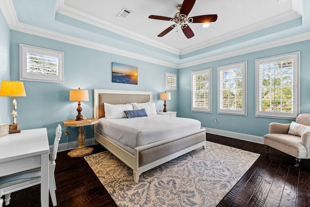 bedroom featuring multiple windows, ceiling fan, and a tray ceiling