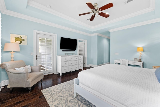 bedroom featuring ceiling fan, dark wood-type flooring, crown molding, and a tray ceiling