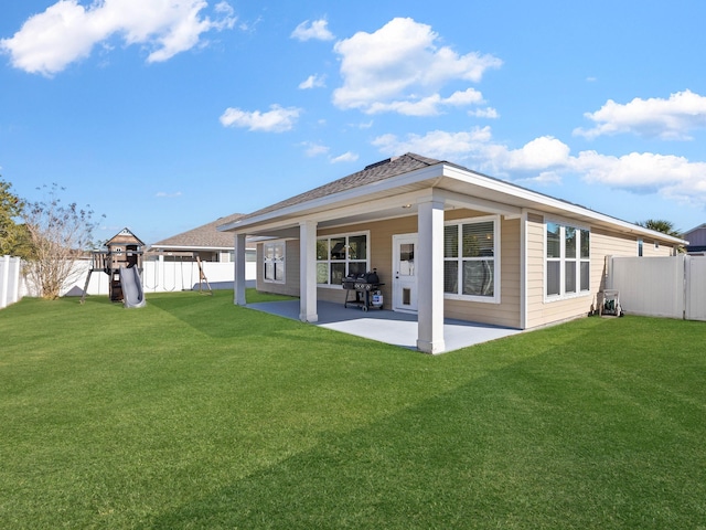 rear view of house featuring a patio, a playground, and a lawn