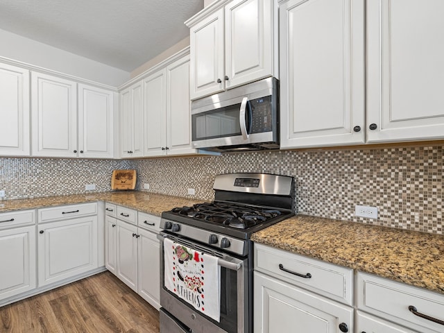 kitchen featuring white cabinets, decorative backsplash, and appliances with stainless steel finishes