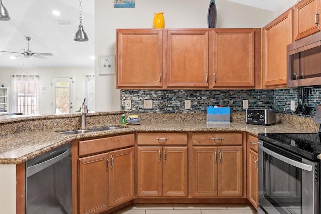 kitchen featuring light stone countertops, appliances with stainless steel finishes, kitchen peninsula, ceiling fan, and sink