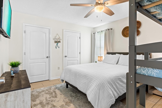 bedroom with ceiling fan and a textured ceiling