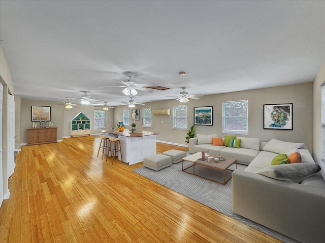 unfurnished living room featuring a wall mounted air conditioner and light hardwood / wood-style flooring