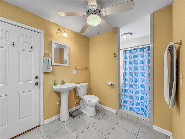 bathroom featuring a shower with curtain, ceiling fan, sink, tile patterned flooring, and toilet