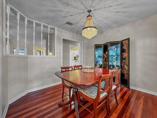 dining area with hardwood / wood-style flooring, a notable chandelier, and a textured ceiling