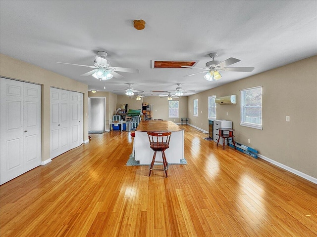 game room featuring a wall unit AC and light wood-type flooring