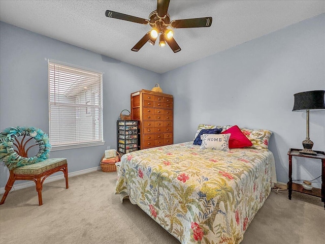 carpeted bedroom with ceiling fan and a textured ceiling