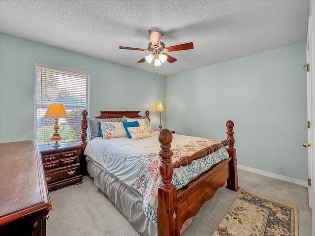 carpeted bedroom featuring ceiling fan and a textured ceiling