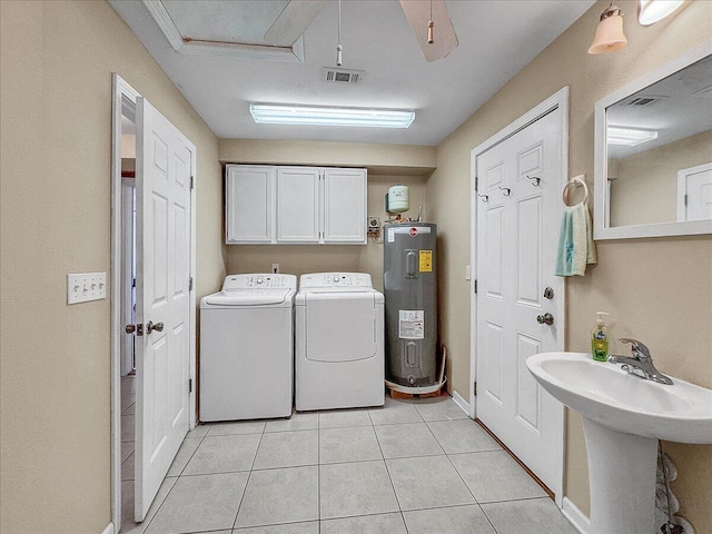 clothes washing area with cabinets, sink, water heater, light tile patterned floors, and independent washer and dryer