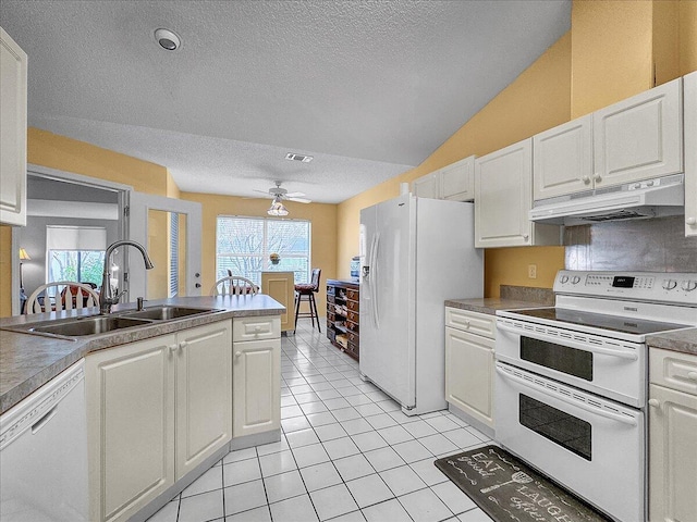 kitchen with white appliances, lofted ceiling, white cabinets, sink, and ceiling fan