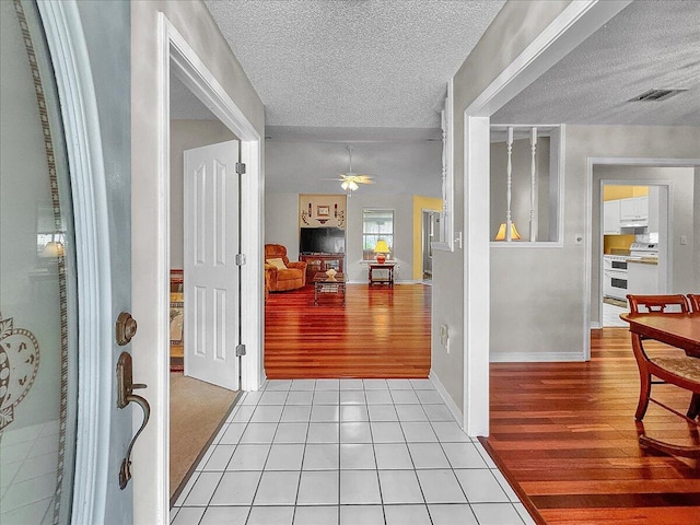 hallway with light tile patterned flooring and a textured ceiling