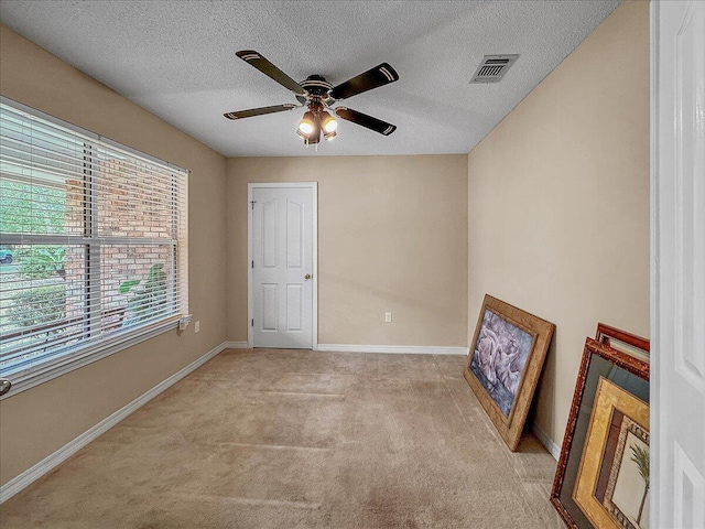 unfurnished bedroom with a textured ceiling, ceiling fan, and light carpet