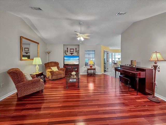 living room featuring hardwood / wood-style floors, a textured ceiling, ceiling fan, and lofted ceiling