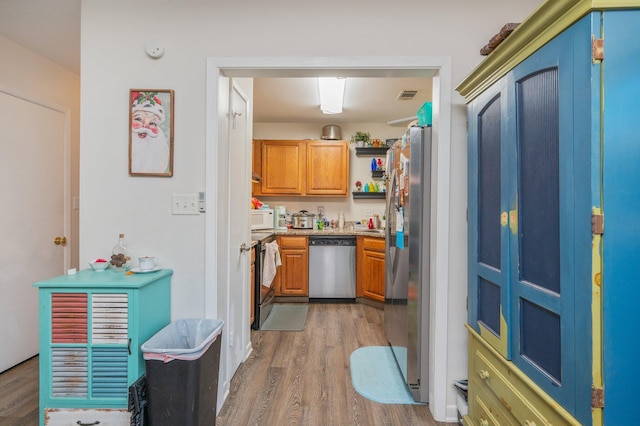 kitchen with stainless steel appliances and hardwood / wood-style floors