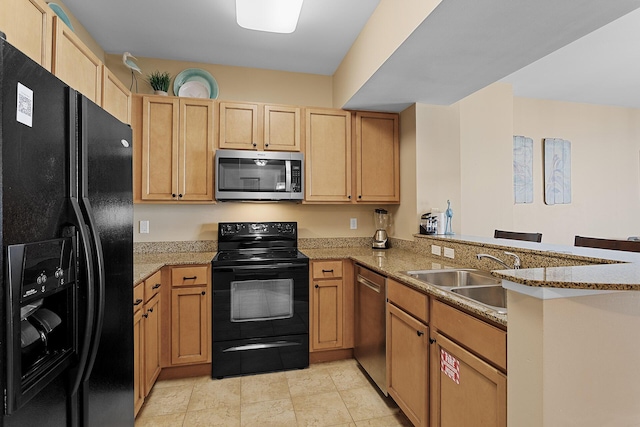 kitchen with sink, kitchen peninsula, light stone counters, and black appliances