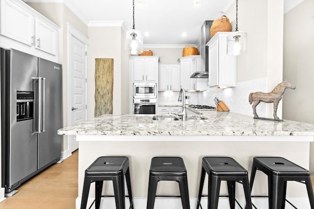 kitchen with decorative light fixtures, stainless steel appliances, crown molding, white cabinetry, and sink