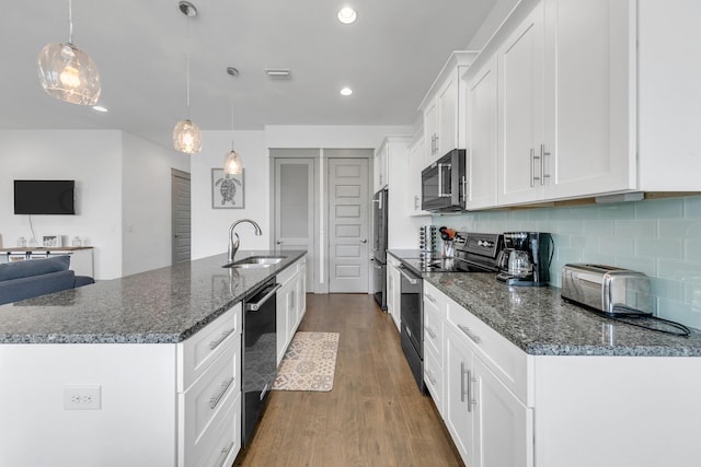 kitchen featuring pendant lighting, black appliances, white cabinets, sink, and tasteful backsplash