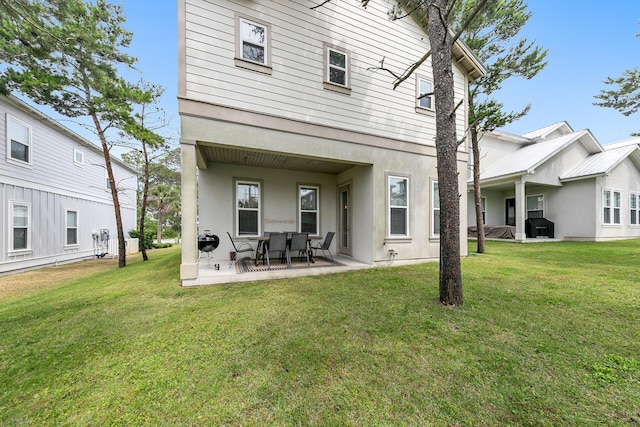 rear view of property with a yard and a patio