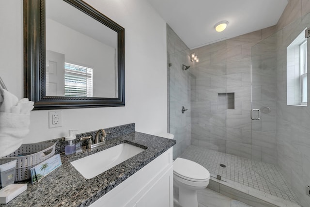 bathroom featuring vanity, toilet, and an enclosed shower