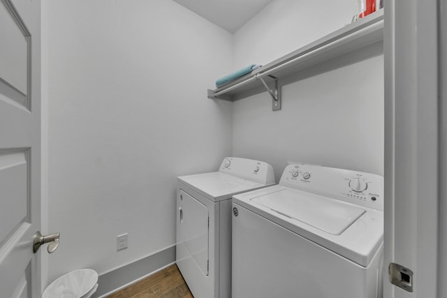 clothes washing area with separate washer and dryer and dark hardwood / wood-style floors