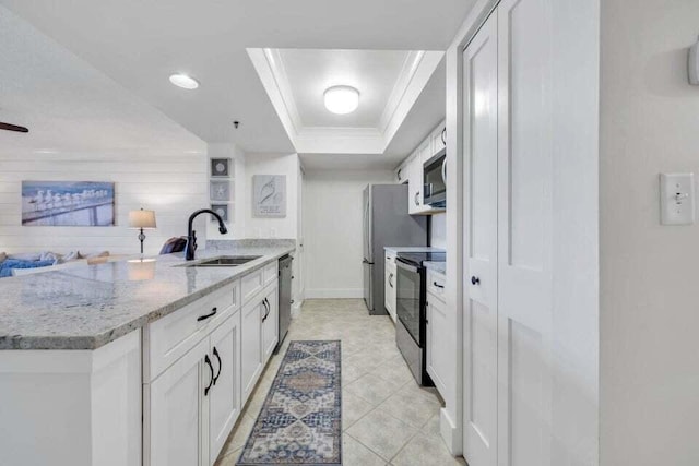 kitchen featuring stainless steel appliances, a raised ceiling, white cabinetry, light tile patterned flooring, and sink