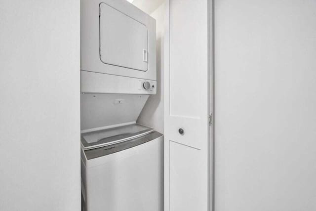 laundry room with stacked washing maching and dryer