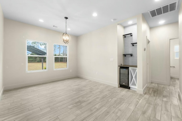 interior space with bar, light hardwood / wood-style flooring, a chandelier, and wine cooler