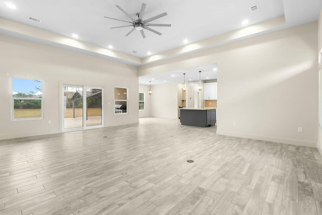 unfurnished living room featuring ceiling fan and light hardwood / wood-style flooring